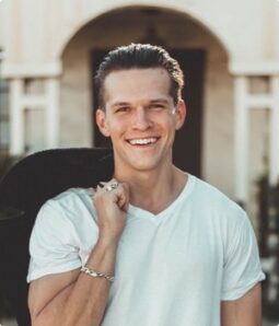 Smiling man in white t-shirt with jacket over shoulder