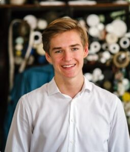 Young man smiling in a white shirt, volunteering