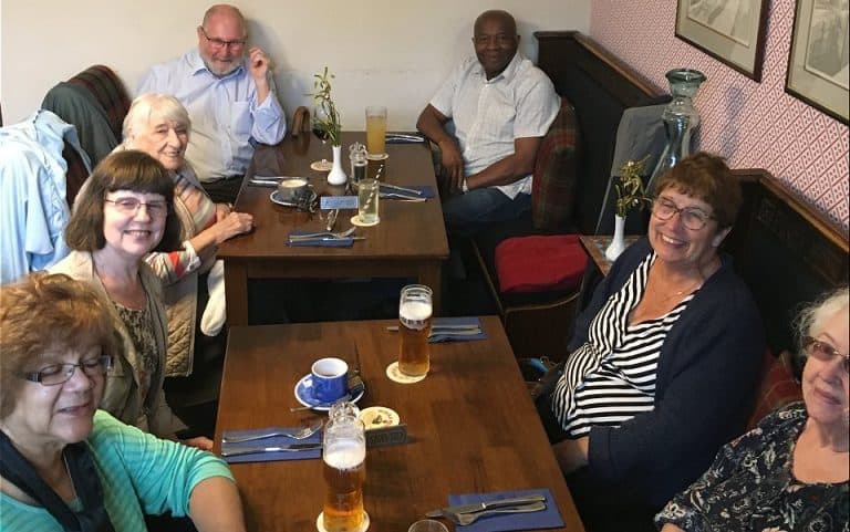 Group of friends dining at a restaurant on a Hard of Hearing Boat Trip.