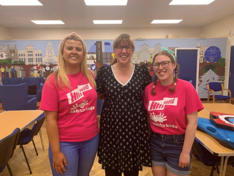 Three women smiling for the camera.