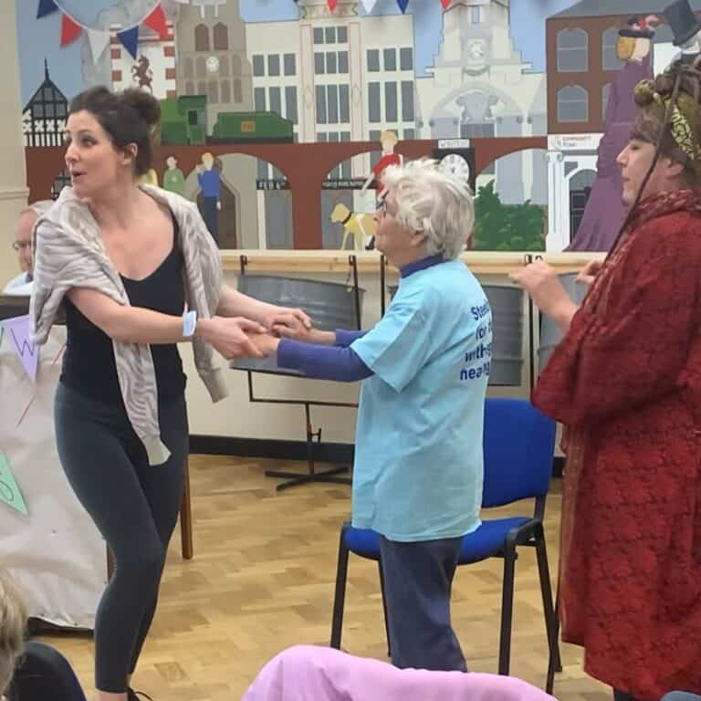 Group of three women dancing in front of a piano.