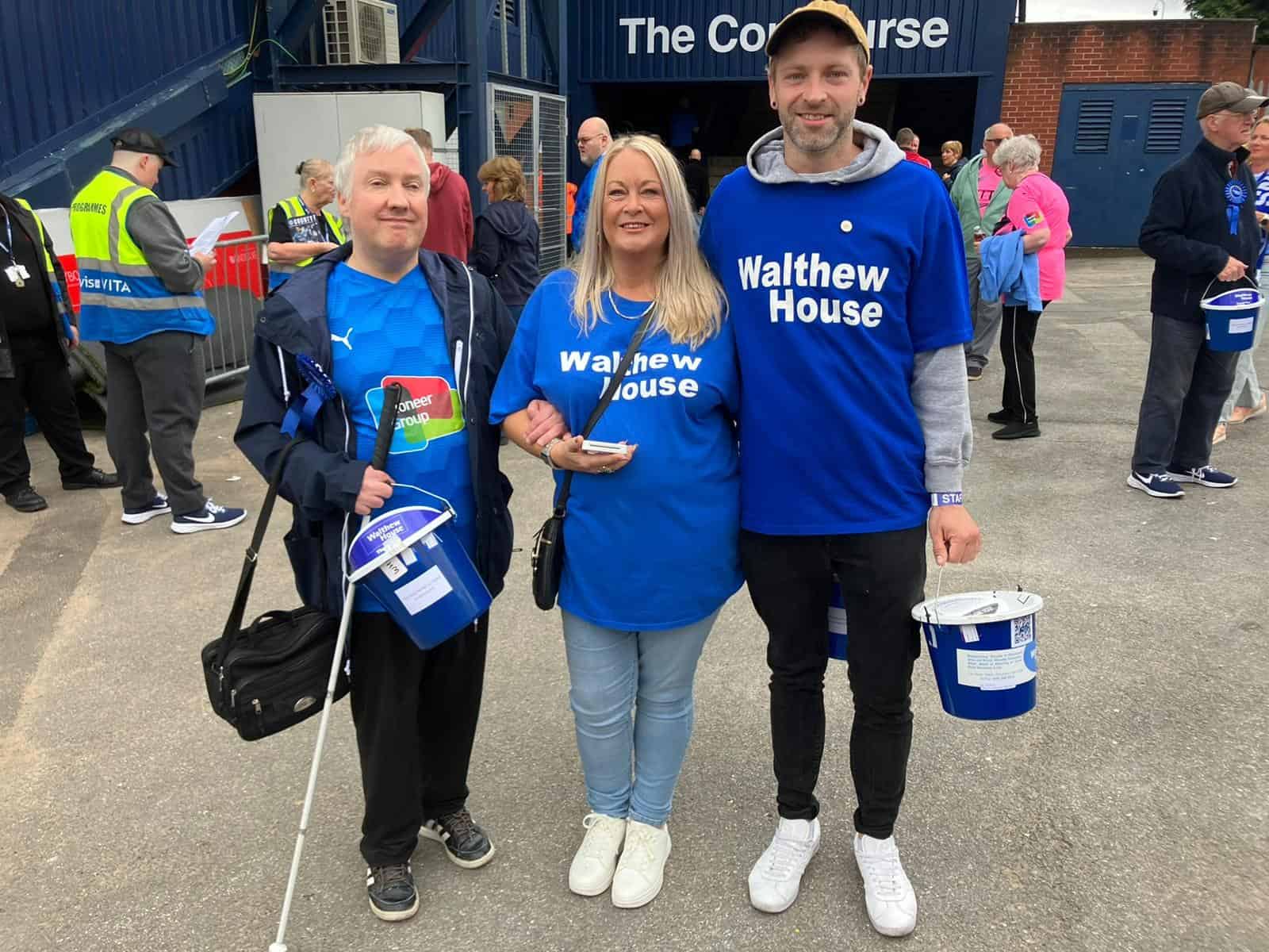Three volunteers with buckets at County match