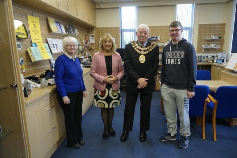 Four people at Walthew House during a mayoral visit pose for a photo.