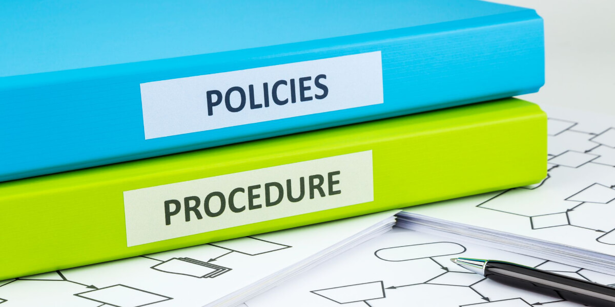 Two binders labeled "Policies" and "Procedure" sit atop documents outlining Walthew House policies.