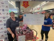 Two women holding a giant check for £6722.55 made out to Walthew House at Co-op.