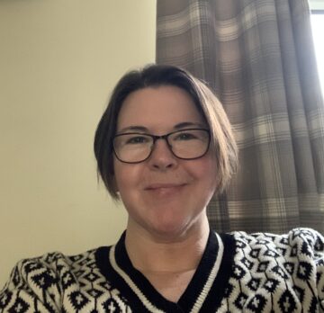 Friendly woman wearing glasses and a black and white sweater