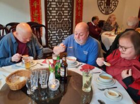 People eating soup at a round table in a Chinese restaurant, with decorations in the background. People eating soup at a round table in a Chinese restaurant, with decorations in the background.