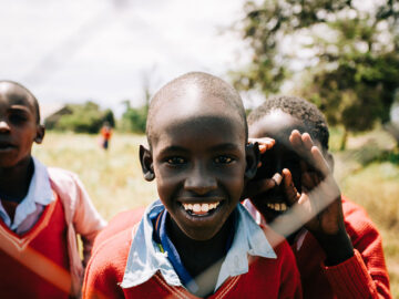 Smiling African children in red sweaters, part of school 