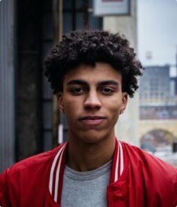 Young man with curly hair wearing a red jacket
